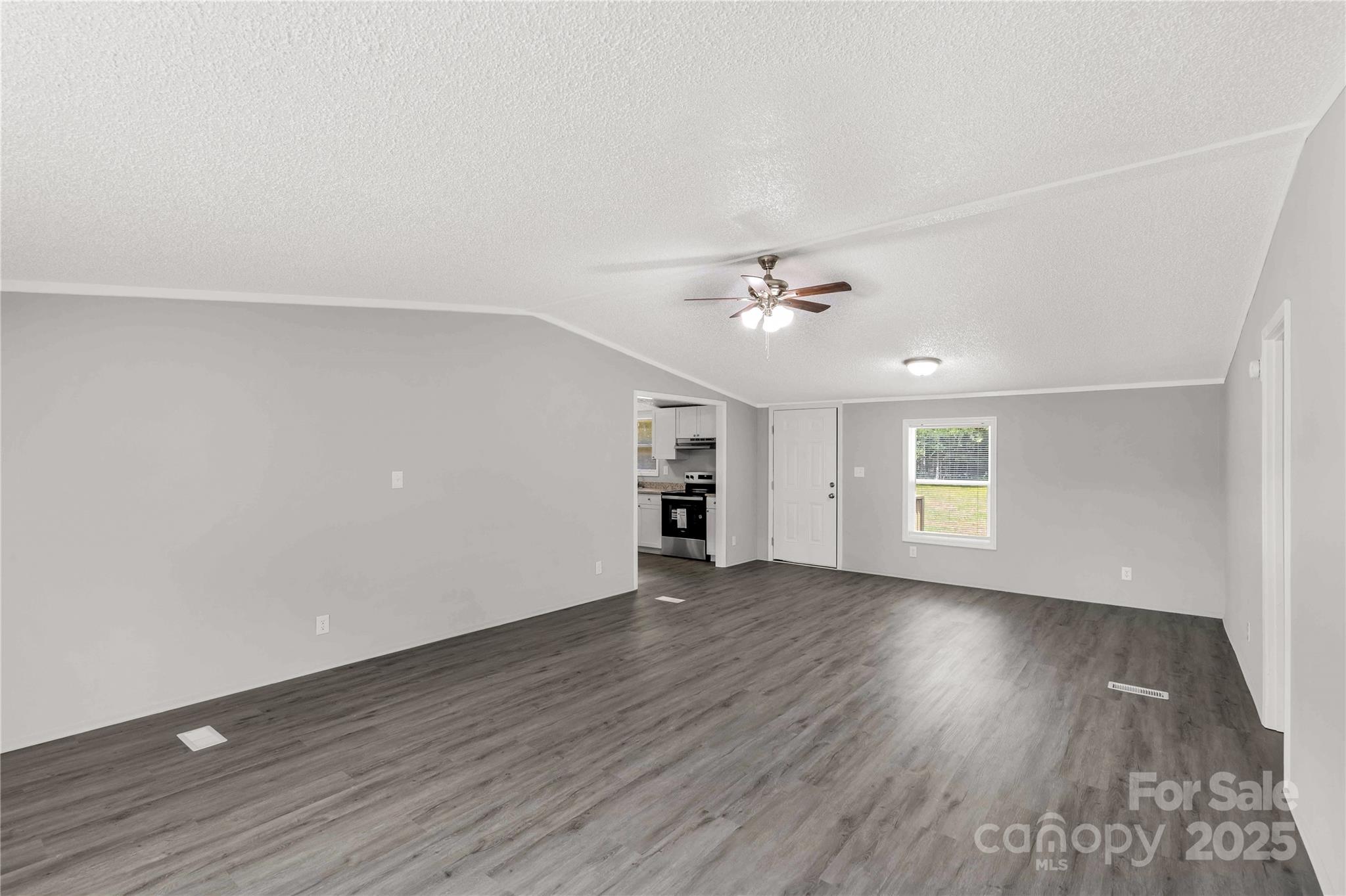 2007 Sugar Hill Road York, SC 29745 - Photo 10 of 36 an empty room with wooden floor chandelier fan and windows