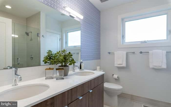 628 I Street Northeast, Unit 3 Washington, DC 20002 - Photo 24 of 32 a bathroom with a granite countertop sink toilet and mirror