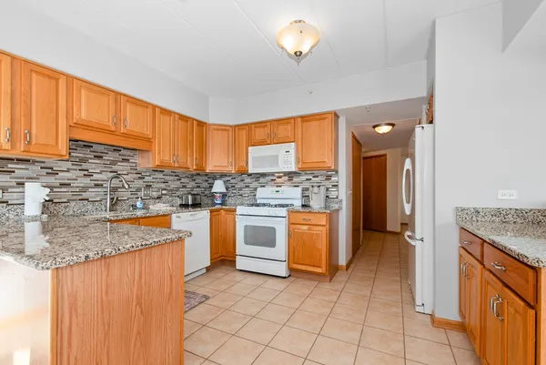 a kitchen with stainless steel appliances granite countertop a stove a sink dishwasher and a refrigerator