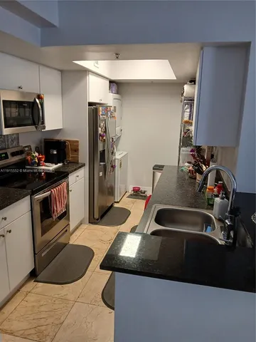 a kitchen with a sink a stove and chairs