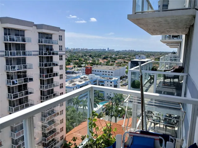 a balcony view with couple of cars parked in front of it