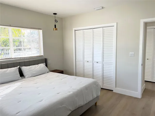 a bedroom with a large bed and a window