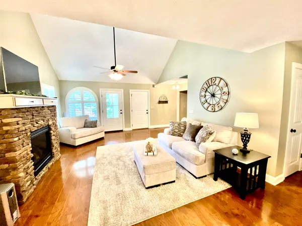 a living room with furniture a fireplace and a flat screen tv