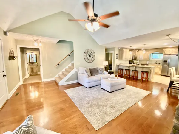 a living room with kitchen island furniture and a chandelier