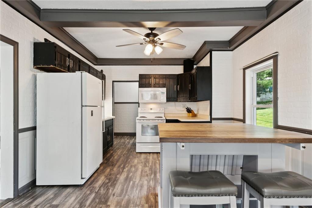 729 Athena Drive Export, PA 15632 - Photo 7 of 31 a kitchen with stainless steel appliances kitchen island granite countertop a refrigerator a sink dishwasher a stove and a dining table with wooden floor