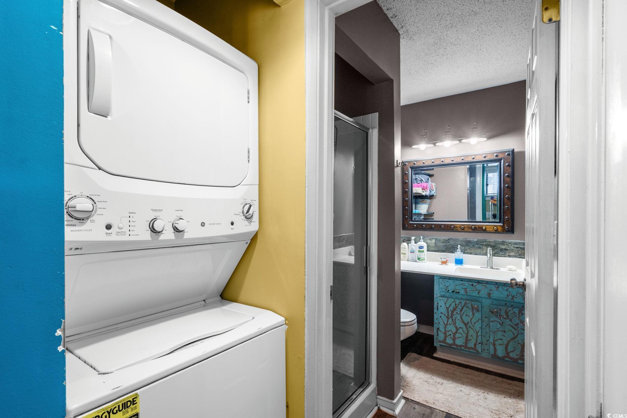 351 Lake Arrowhead Road, Unit 275 Myrtle Beach, SC 29572 - Photo 10 of 37 Laundry room with a textured ceiling, estacked washer and dryer, and wood finished floors
