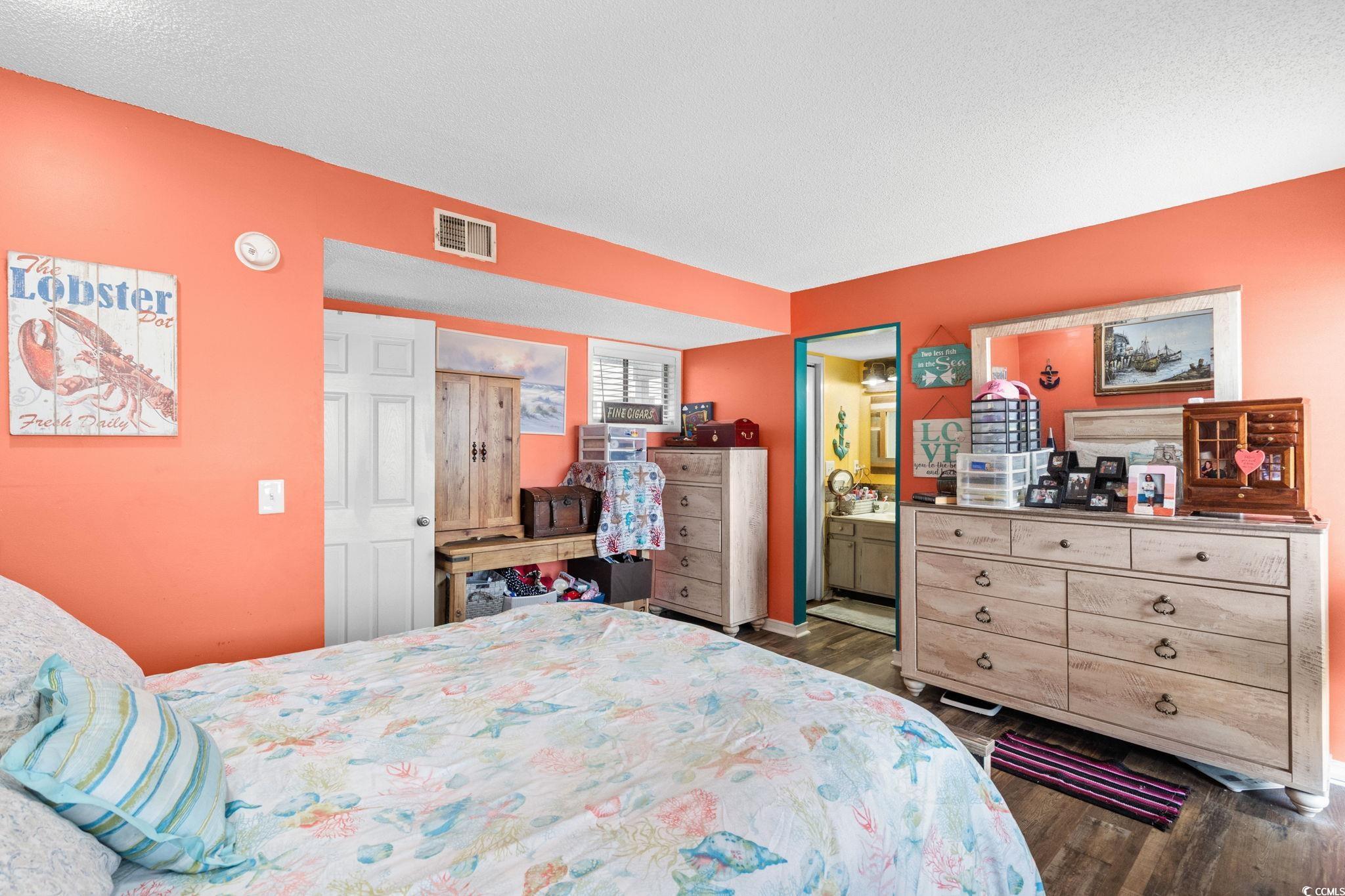 351 Lake Arrowhead Road, Unit 275 Myrtle Beach, SC 29572 - Photo 13 of 37 Bedroom with dark wood-type flooring, a textured ceiling, and ensuite bathroom