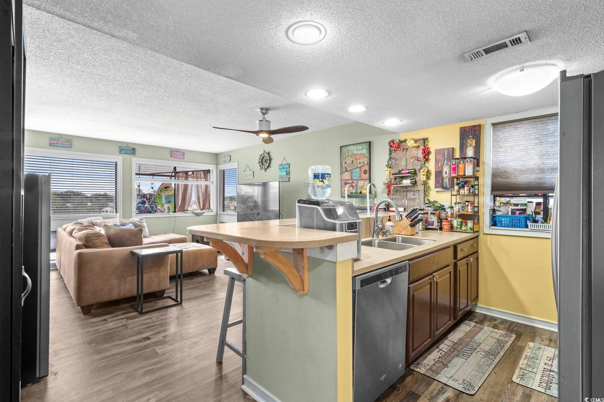 351 Lake Arrowhead Road, Unit 275 Myrtle Beach, SC 29572 - Photo 37 of 37 Kitchen featuring light countertops, a peninsula, a breakfast bar, a textured ceiling, and open floor plan