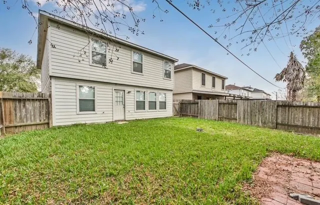a view of a house with backyard and wooden fence
