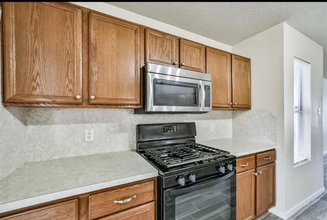 a kitchen with wooden cabinets and a stove top oven