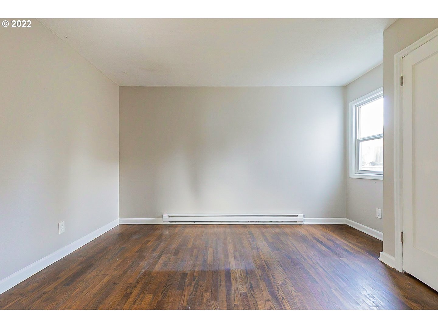 6930 Northeast Roselawn Street Portland, OR 97218 - Photo 19 of 31 a view of an empty room with wooden floor and a window