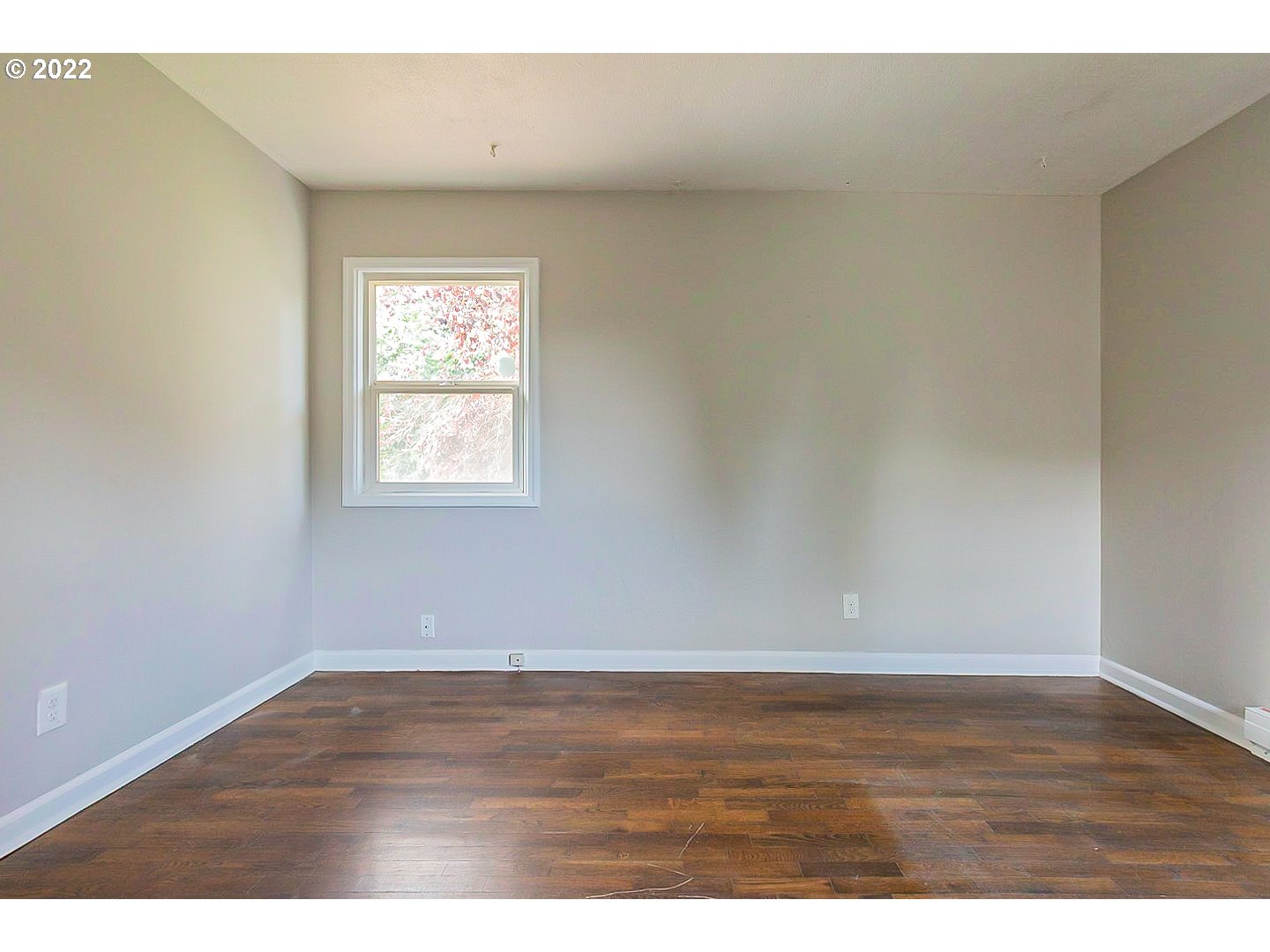 6930 Northeast Roselawn Street Portland, OR 97218 - Photo 22 of 31 a view of an empty room with wooden floor and a window