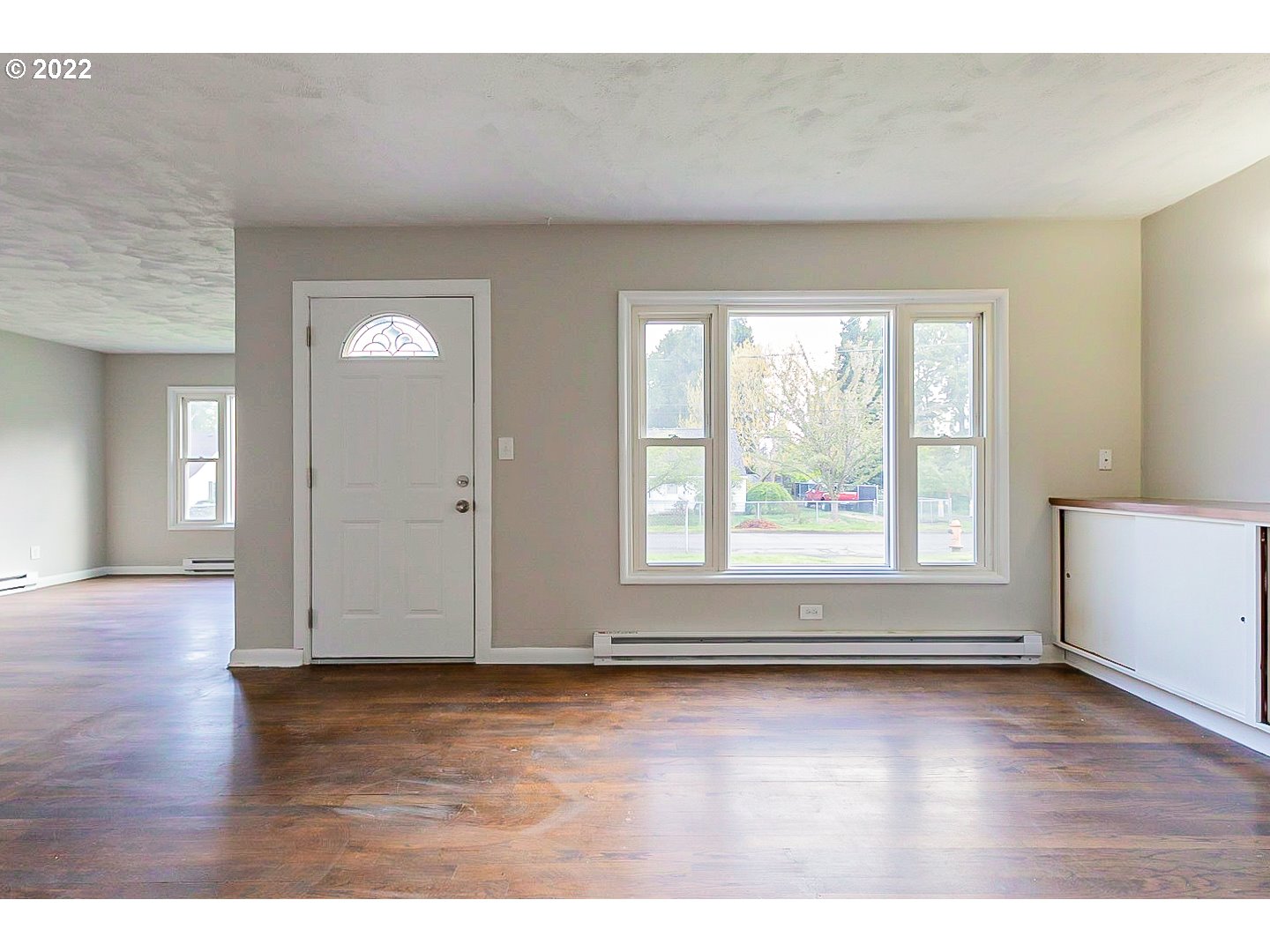 6930 Northeast Roselawn Street Portland, OR 97218 - Photo 3 of 31 an empty room with wooden floor and windows