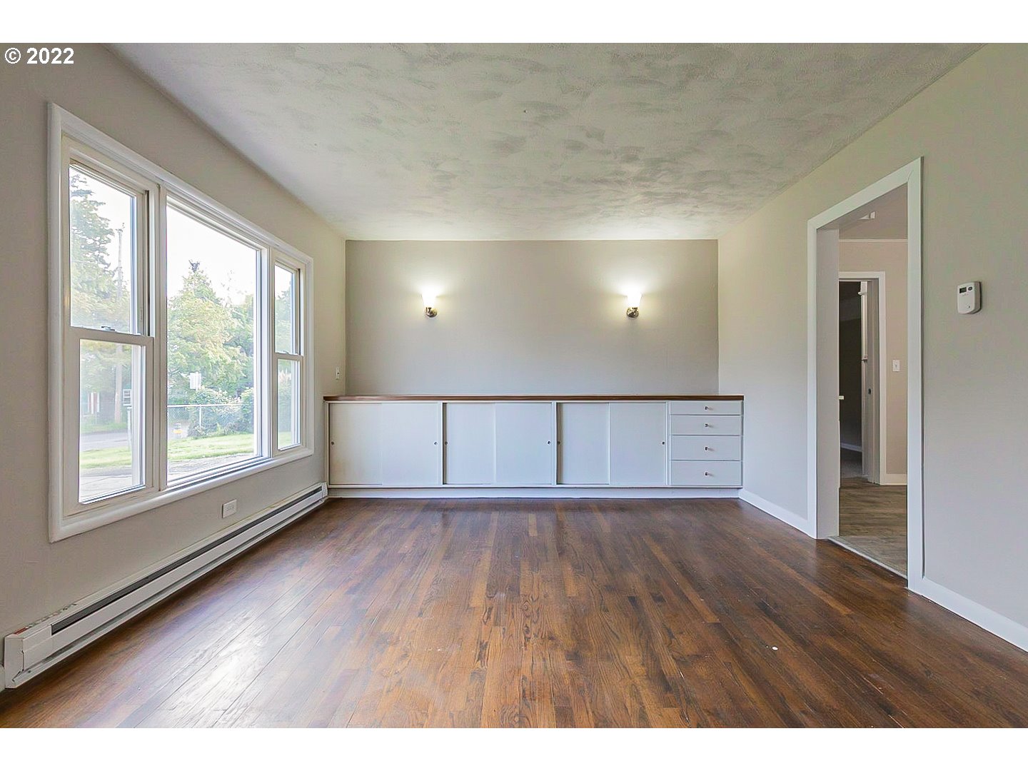 6930 Northeast Roselawn Street Portland, OR 97218 - Photo 9 of 31 a view of an empty room with wooden floor and a window