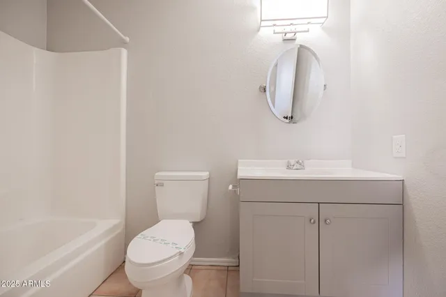 a bathroom with a toilet sink vanity tub and mirror