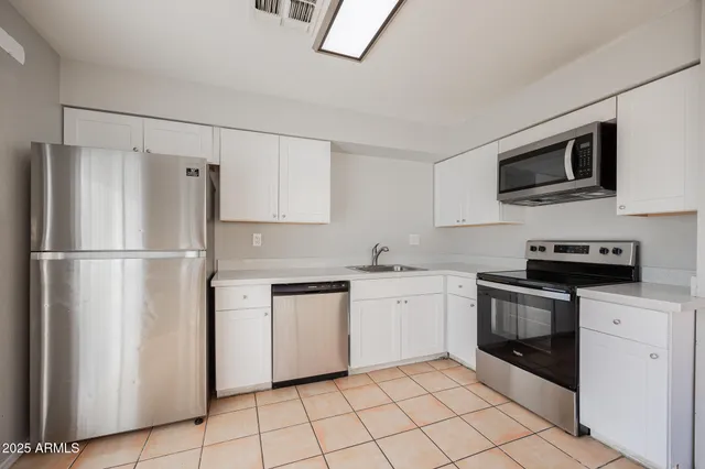 a kitchen with stainless steel appliances granite countertop a refrigerator sink and stove