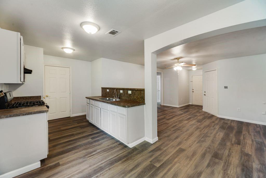 2526 Exeter Avenue Dallas, TX 75216 - Photo 11 of 19 Kitchen featuring white cabinetry, dark speckled countertops, and a gas range