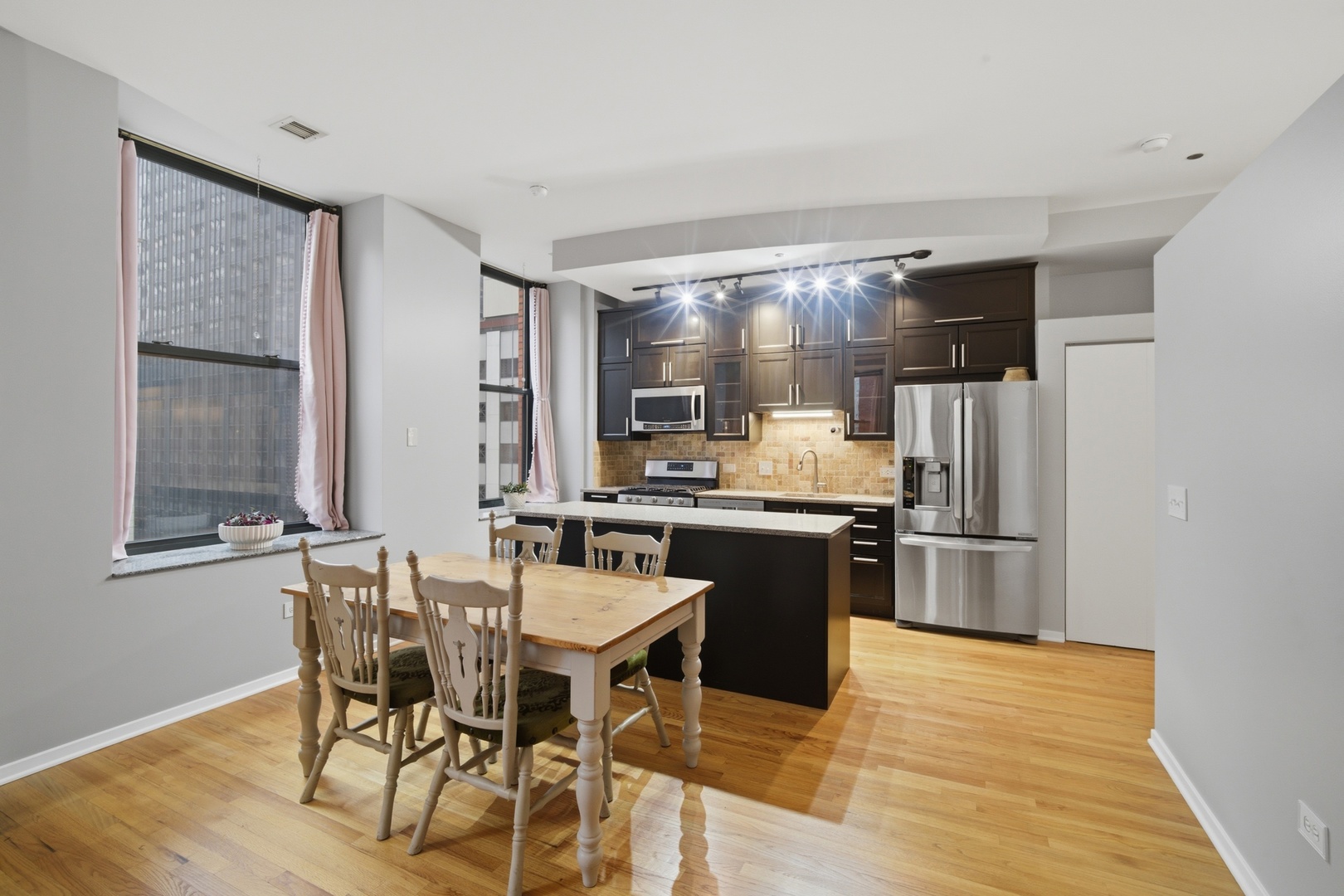 208 West Washington Street, Unit 910 Chicago, IL 60606 - Photo 6 of 18 a kitchen with stainless steel appliances kitchen island granite countertop a refrigerator and a stove top oven