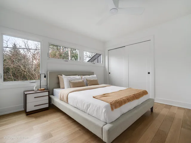 a bedroom with a bed and a large window
