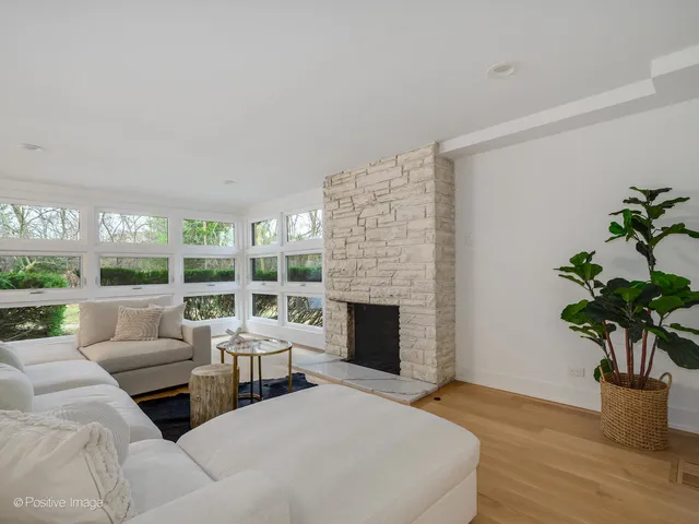 a living room with furniture large window and a fireplace