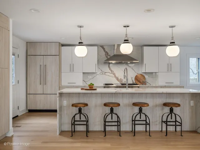 a kitchen with cabinets and chairs