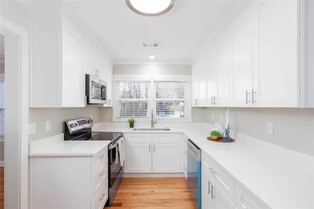 a kitchen with a sink a stove cabinets and a window