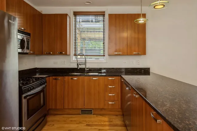a kitchen with granite countertop a sink a stove and cabinets