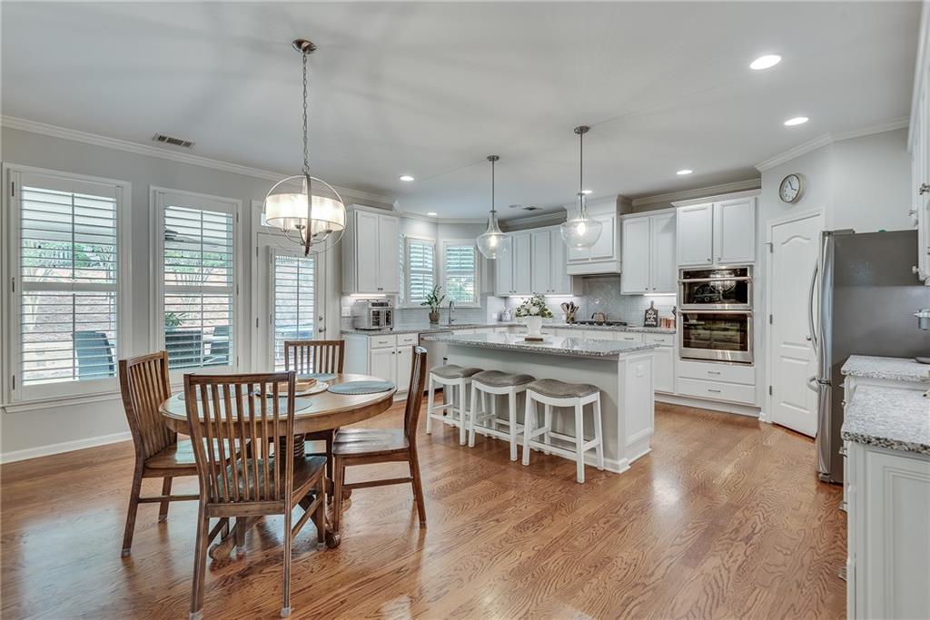 3315 Thimbleberry Trail Dacula, GA 30019 - Photo 16 of 59 a dining room with stainless steel appliances granite countertop a stove a refrigerator a oven a sink with a dining table and chairs