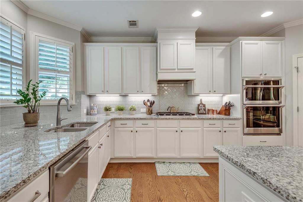 3315 Thimbleberry Trail Dacula, GA 30019 - Photo 18 of 59 a kitchen with granite countertop a sink stainless steel appliances and cabinets