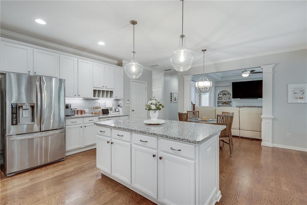 3315 Thimbleberry Trail Dacula, GA 30019 - Photo 21 of 59 a kitchen with stainless steel appliances kitchen island granite countertop a stove a sink and a refrigerator