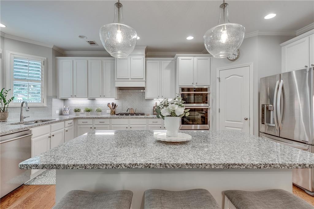 3315 Thimbleberry Trail Dacula, GA 30019 - Photo 23 of 59 a kitchen with stainless steel appliances granite countertop a sink refrigerator and cabinets