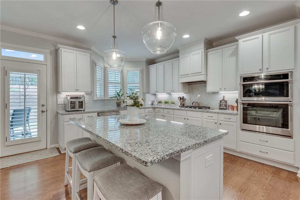 3315 Thimbleberry Trail Dacula, GA 30019 - Photo 24 of 59 a kitchen with kitchen island granite countertop stainless steel appliances a sink a stove a microwave a center island and cabinets