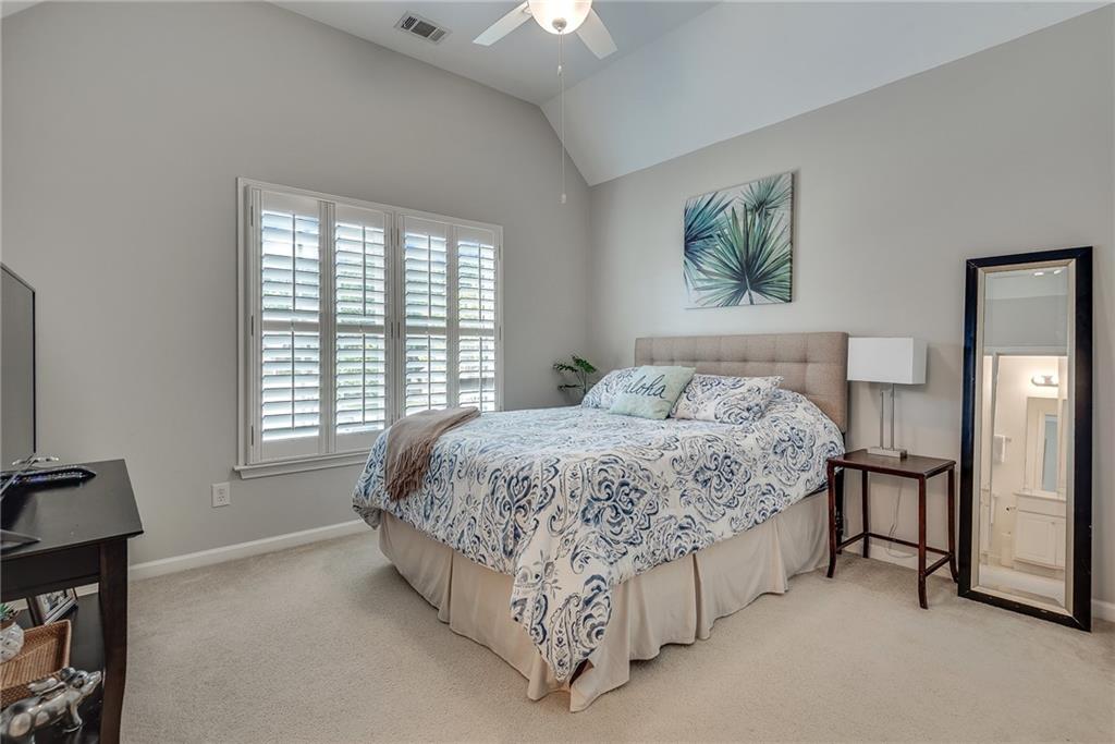3315 Thimbleberry Trail Dacula, GA 30019 - Photo 36 of 59 a spacious bedroom with a bed a couch and a chandelier