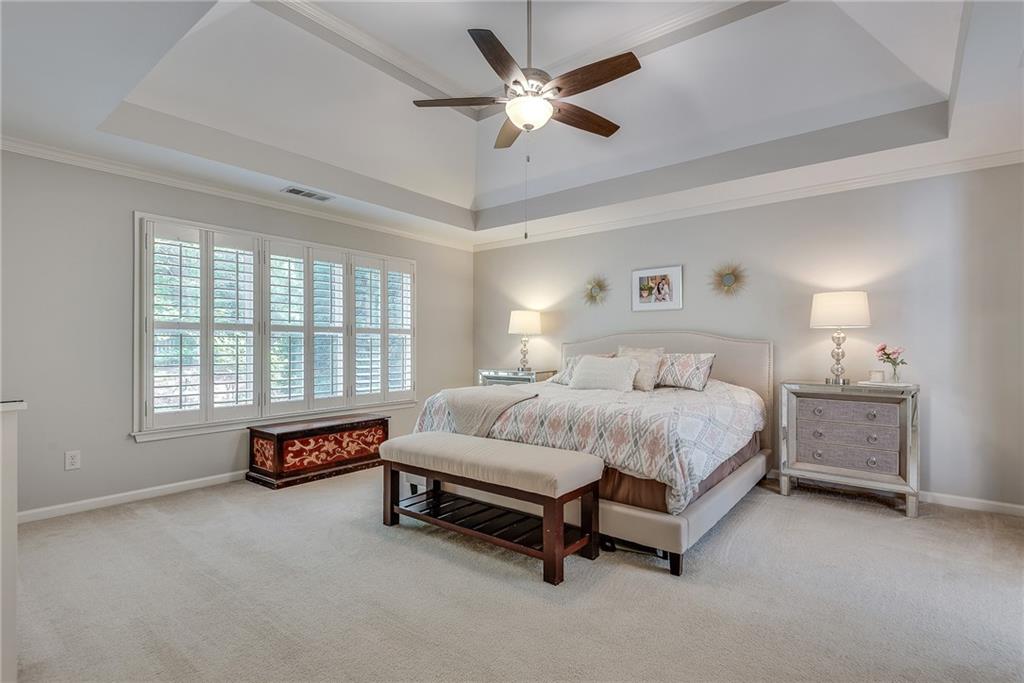 3315 Thimbleberry Trail Dacula, GA 30019 - Photo 39 of 59 a spacious bedroom with a bed and a chandelier