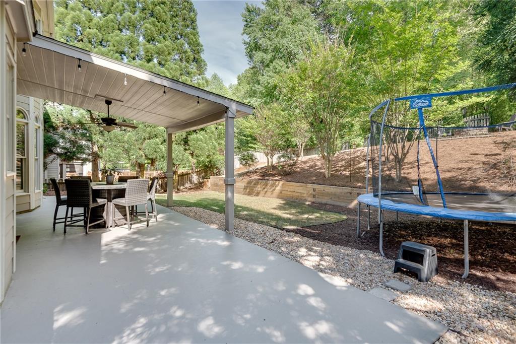 3315 Thimbleberry Trail Dacula, GA 30019 - Photo 47 of 59 a view of a patio with a table chairs and a backyard