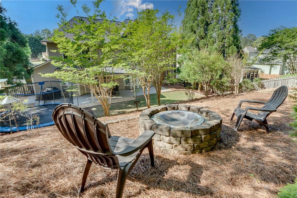 3315 Thimbleberry Trail Dacula, GA 30019 - Photo 49 of 59 a view of a backyard with table and chairs and potted plants