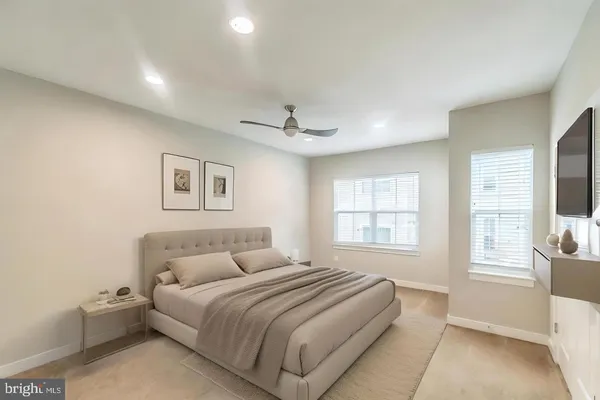 an empty room with windows and ceiling fan