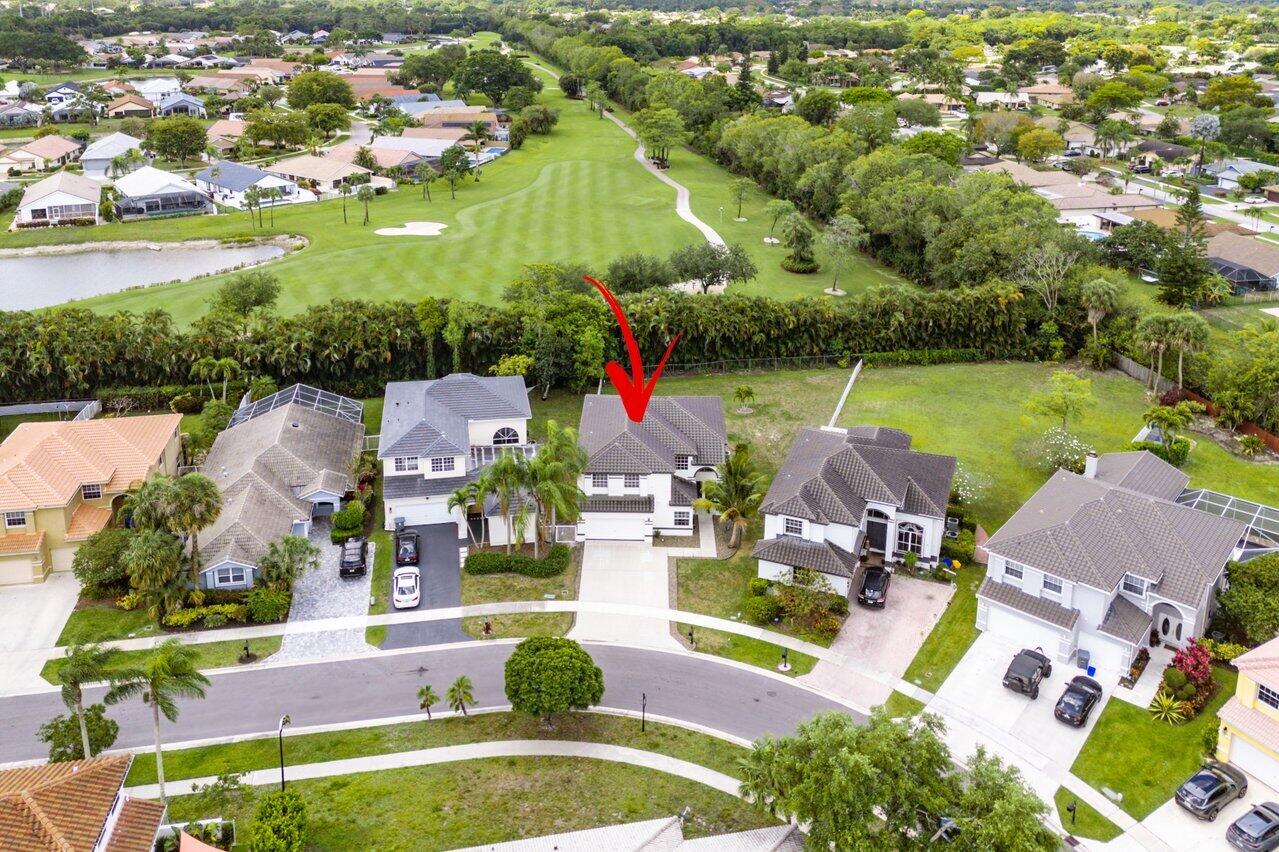 an aerial view of a house with a garden and lake view