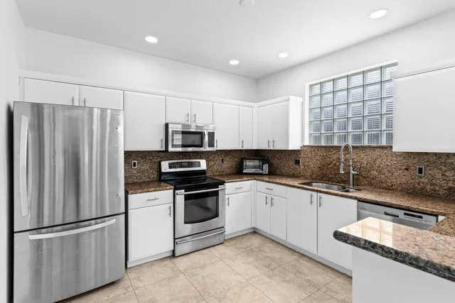 a view of a livingroom with a workspace a sink and a refrigerator