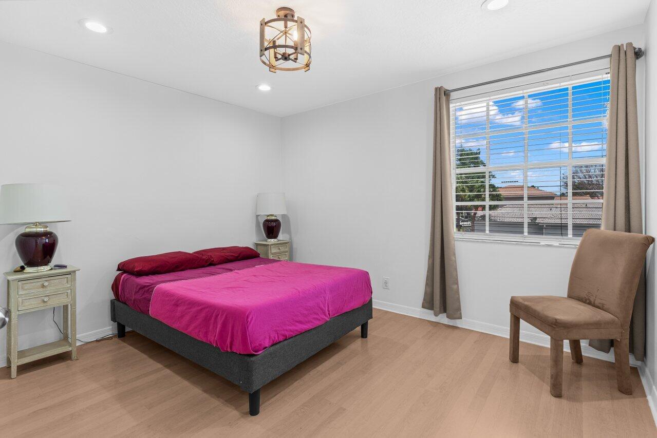 11157 Harbour Springs Circle Boca Raton, FL 33428 - Photo 40 of 68 a bedroom with a bed and chair