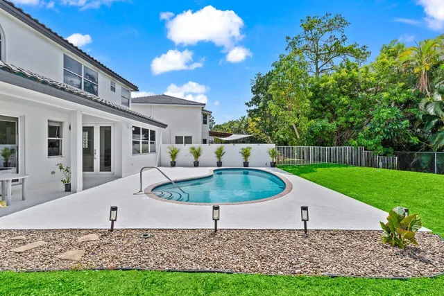 a view of a swimming pool with a yard and sitting area