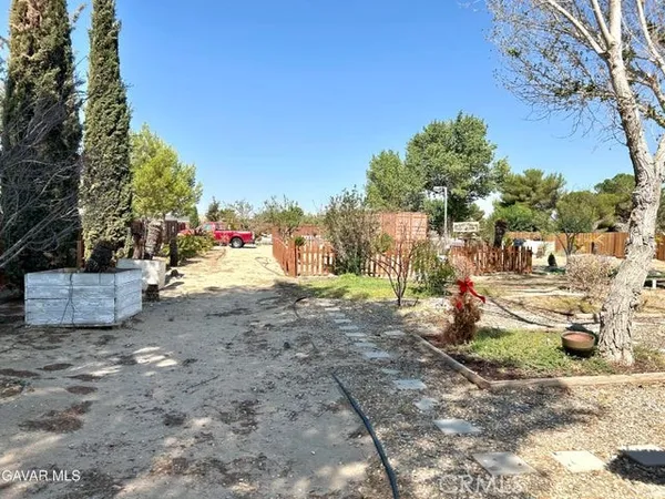 a view of a dirt road with a building in the background