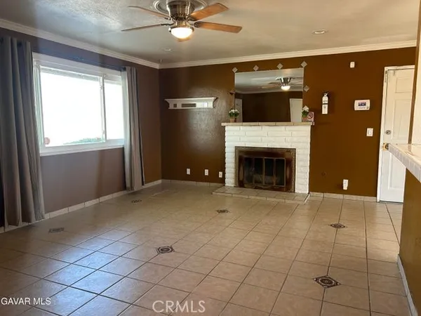 a view of an empty room with a fireplace and a window