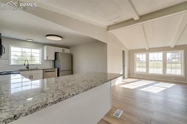 a view of living room with granite countertop hardwood floor and a sink