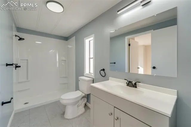 a bathroom with a toilet sink a mirror and shower