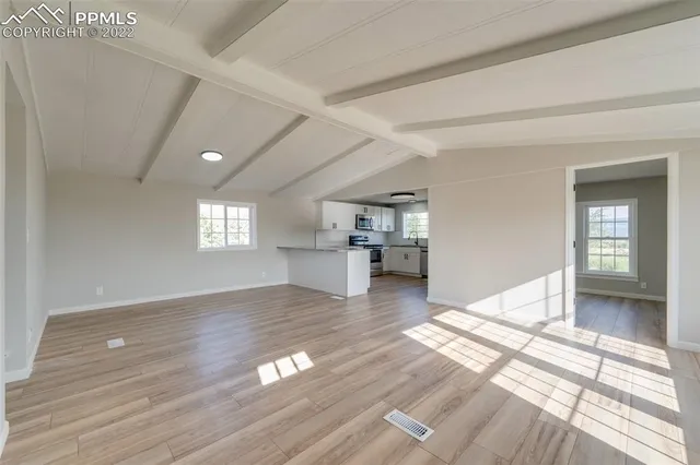 a view of empty room with wooden floor and window