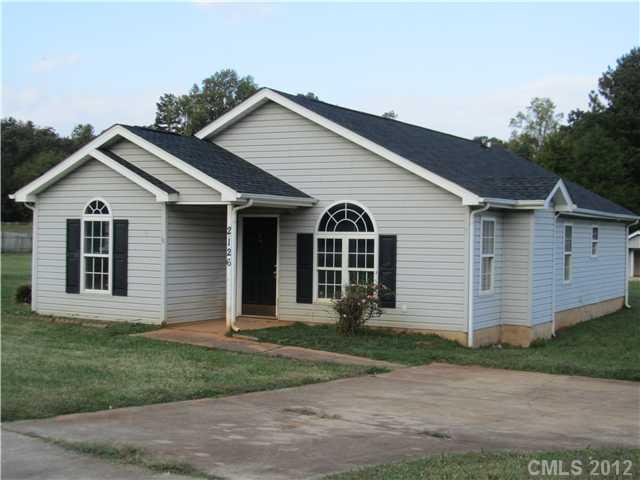 2126 Tryon Courthouse Road Bessemer City, NC 28016 - Photo 1 of 1 a view of a white house next to a yard and garage
