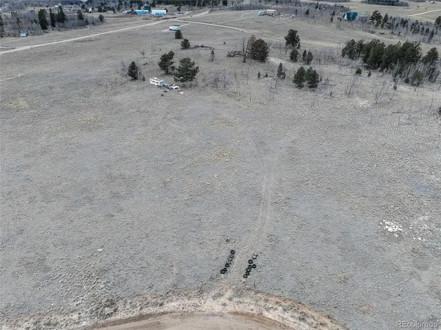 a view of a dry yard with wooden fence