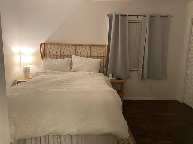 a bedroom with a bed and wooden floor