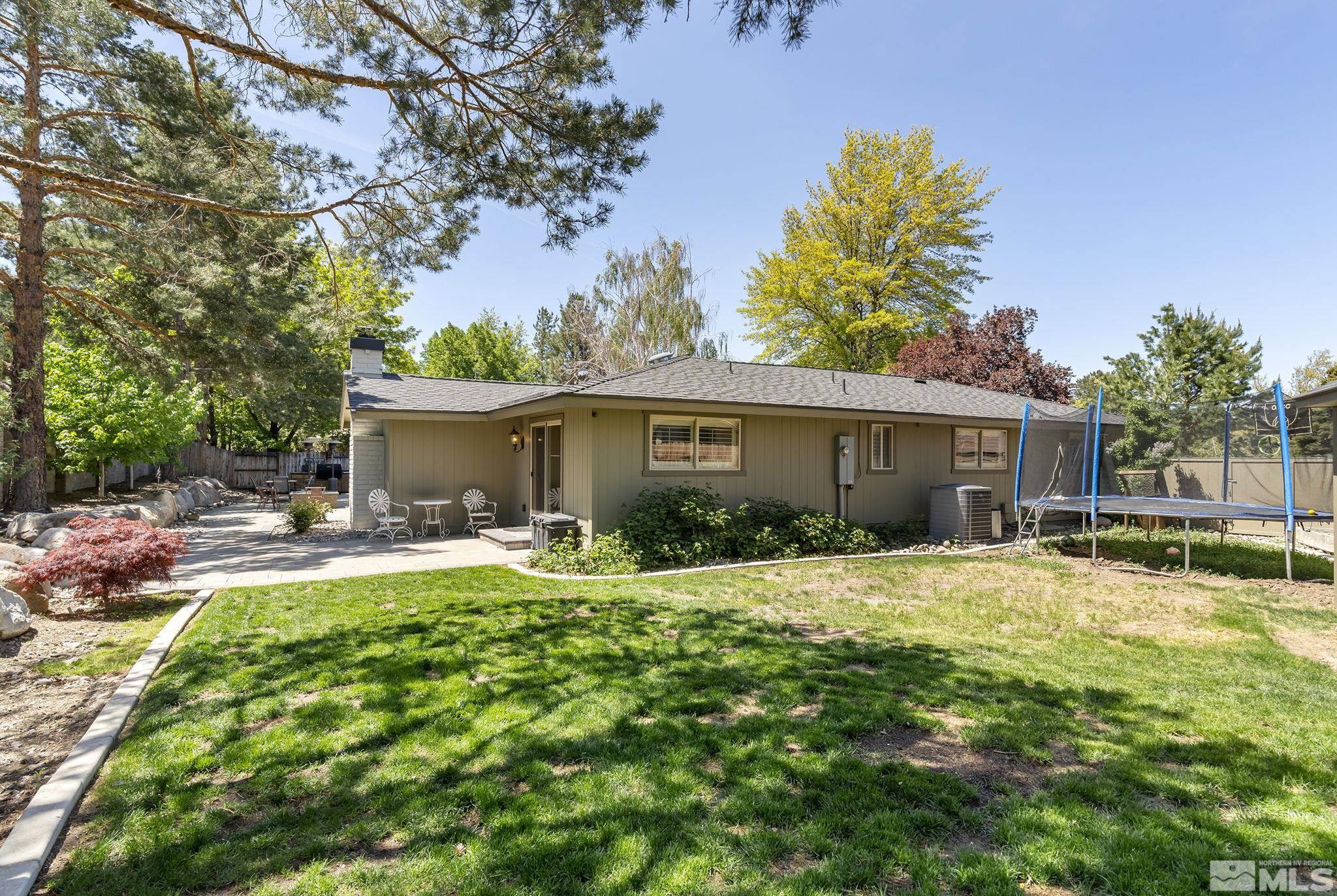 1490 Shewmaker Court Reno, NV 89509 - Photo 36 of 40 a view of a house with a yard and table and chairs under an umbrella
